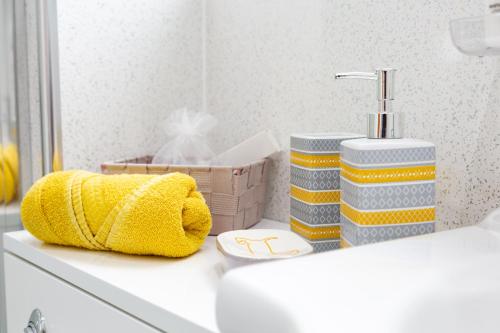 a bathroom with a sink with a yellow towel on a counter at Bothwell Court Apartments in Dunfermline
