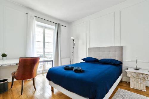 ein Schlafzimmer mit einem blauen Bett und einem Stuhl in der Unterkunft Appartement Quartier Champs-Élysées 3 in Paris