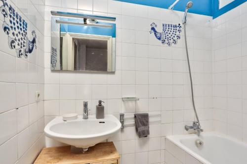 ein weißes Badezimmer mit einem Waschbecken und einer Badewanne in der Unterkunft Appartement Quartier Champs-Élysées 3 in Paris