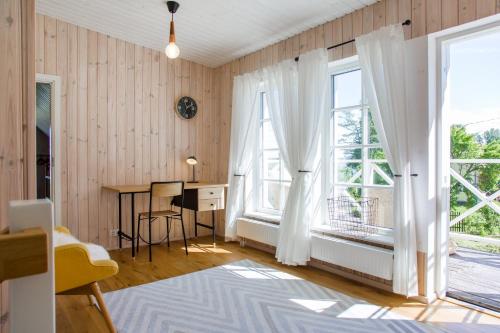 Zimmer mit einem Schreibtisch und 2 Fenstern in der Unterkunft Nordic Bliss beach house - Käsmu in Käsmu