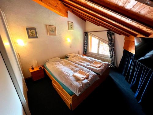 a small bedroom with a bed with a window at Triplex in Villars Centre with Parking in Villars-sur-Ollon