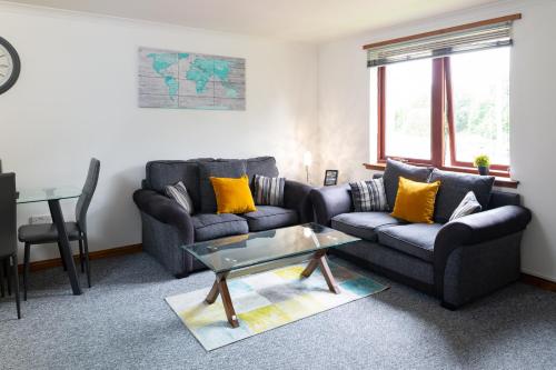 a living room with two couches and a table at Bothwell Court Apartments in Dunfermline