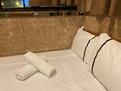 a bed with a roll of paper towels on it at 安捷賓館 Famous Guest House in Hong Kong