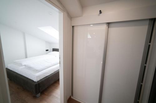 1 dormitorio con 1 cama y puerta corredera de cristal en Luxury Apartments Una Sarajevo, en Sarajevo