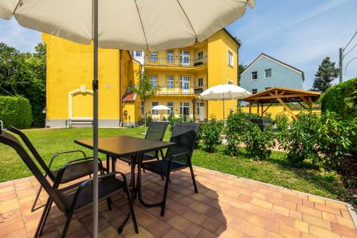 a table and chairs with an umbrella on a patio at Albizia-Apartments in Baden