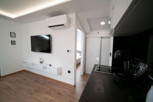 a living room with white walls and a tv on the wall at Luxury Apartments Una Sarajevo in Sarajevo