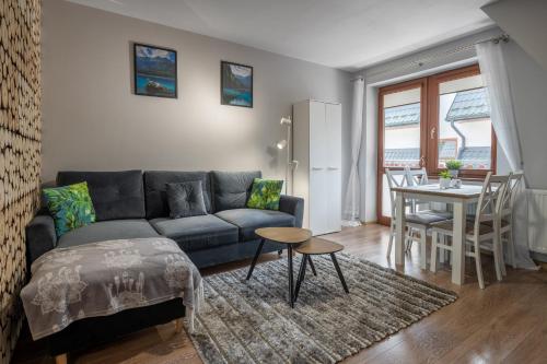 a living room with a couch and a table at RentPlanet - Apartament Antałówka in Zakopane