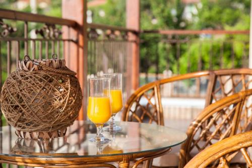 a glass table with two glasses of orange juice on it at Aurelia Villa Kefalonia in Angón