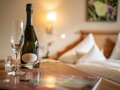 a bottle of wine and a glass on a table at Alpen Glück Hotel Villa Lisa garni in Kirchberg in Tirol