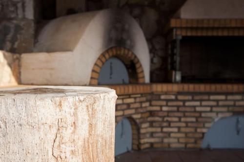 a wooden stump in front of a brick building at Aurelia Villa Kefalonia in Angón