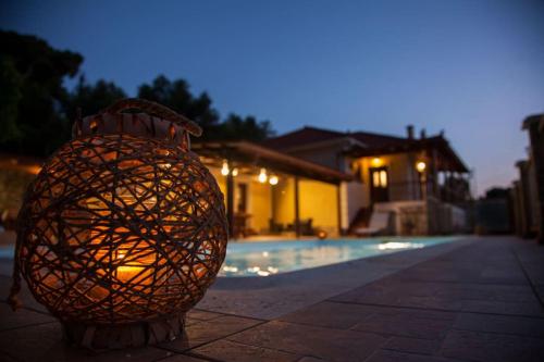 a vase sitting next to a swimming pool at night at Aurelia Villa Kefalonia in Angón