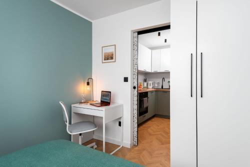 a bedroom with a desk and a bed with a laptop at Kairos Apartments - Diamond - darmowy Parking, ścisłe centrum in Gliwice