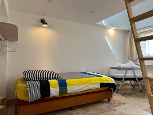 a bedroom with a bed and a ladder and a chair at La Chapelle de Monet - Logis Les Coquelicots in Bois-Jérôme-Saint-Ouen
