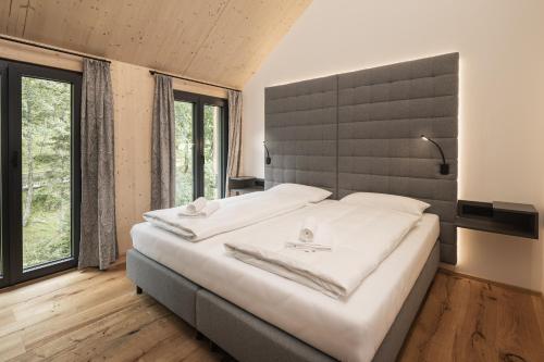 um quarto com uma cama grande e uma janela grande em Rest Apartments & Suiten em Mauterndorf