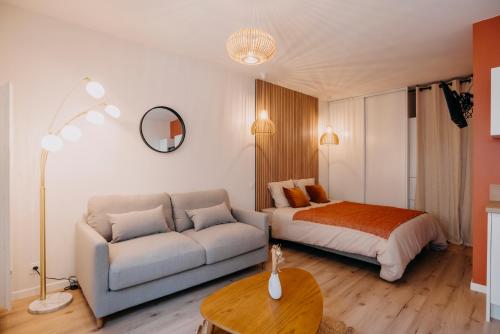 ein Wohnzimmer mit einem Bett und einem Sofa in der Unterkunft L'ATELIER - Coeur de ville - Tout équipé in Cholet