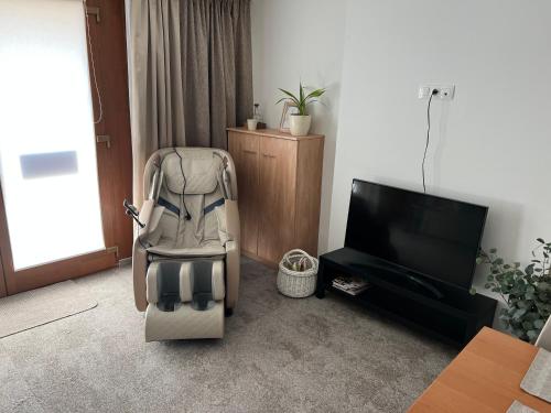 un cochecito sentado en una sala de estar junto a una televisión en Aradi 6 Apartman Pécs en Pécs