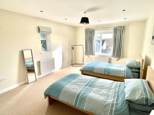 a bedroom with two beds and a mirror at Modern and cosy 4 bedroom home in the Mendip Hills, North Somerset in Axbridge