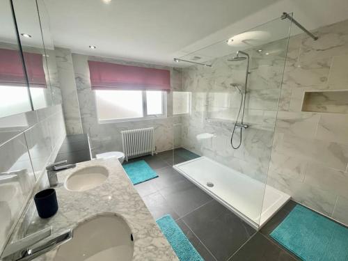 a bathroom with a shower and a sink and a tub at Modern and cosy 4 bedroom home in the Mendip Hills, North Somerset in Axbridge