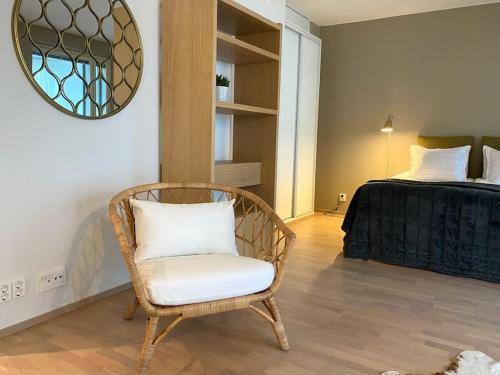 Habitación con silla y cama con espejo. en Tilava yksiö 35,5 m2 merenrannalla en Helsinki