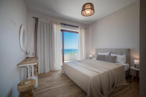 a bedroom with a large bed with a view of the ocean at Kavo Seaside Luxury Apartment in Argasi