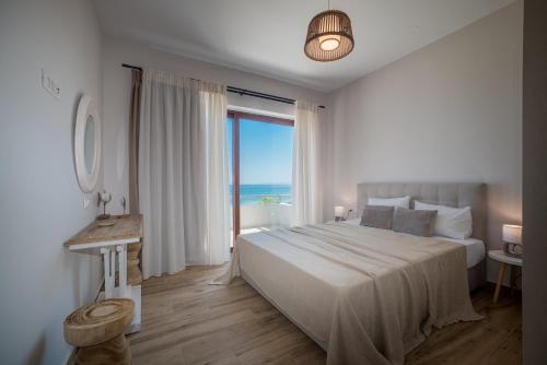 una camera con un grande letto e vista sull'oceano di Kavo Seaside Luxury Apartment ad Argásion