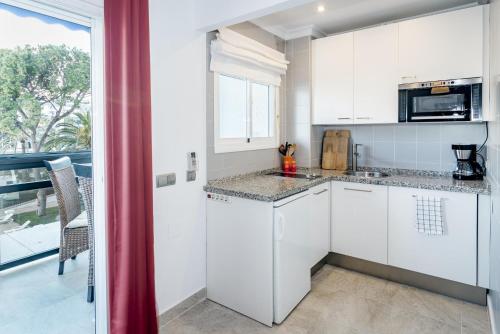 eine Küche mit weißen Schränken und einem großen Fenster in der Unterkunft Sea promenade apartment in Marbella M27 in Marbella