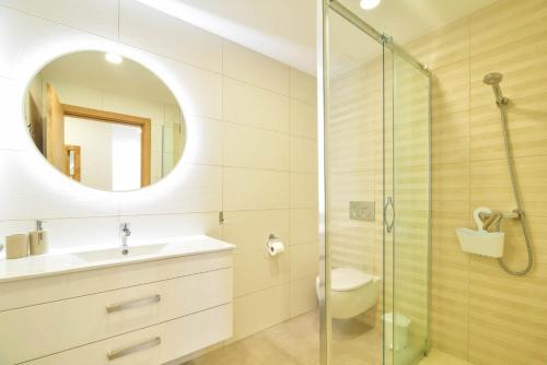 bagno con servizi igienici, lavandino e specchio di Casa Nico OceanView -Apartment 1901 a Portimão