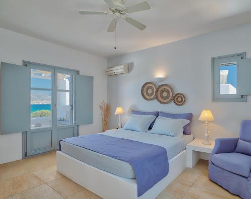 a bedroom with a blue bed and a blue chair at Villa Afroditi in Antiparos