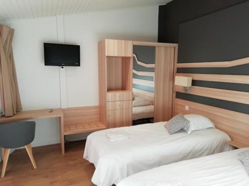 um quarto de hotel com duas camas e uma televisão em VVF Aveyron Najac em Najac