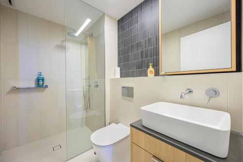 a bathroom with a sink and a toilet and a shower at Stunning New 2 Bedrooms Apt Shopping & Parking in Sydney