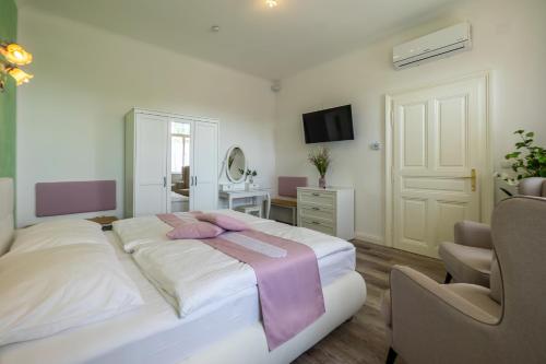 a bedroom with a large bed with a purple blanket on it at Albizia-Apartments in Baden