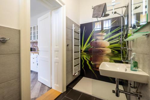 a bathroom with a sink and a painting on the wall at Albizia-Apartments in Baden