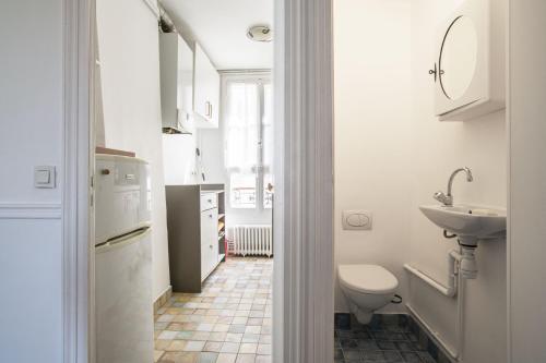 une salle de bain blanche avec un lavabo et des toilettes dans l'établissement Pick A Flat's Apartment in Le Marais - Boulevard Morland, à Paris