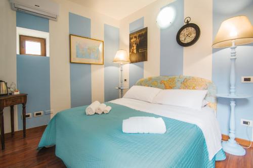 a bedroom with a bed with a clock on the wall at La Fabbrica dell'Oro in Asti