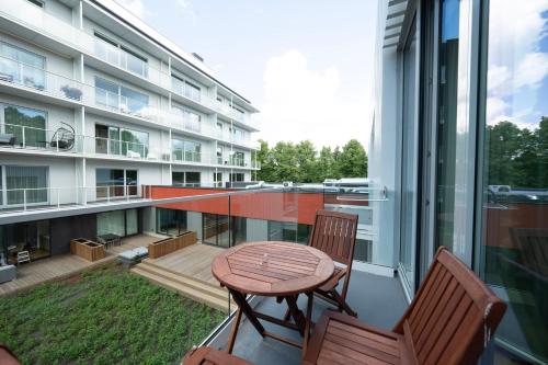 een patio met een tafel en 2 stoelen op een balkon bij Bob W Pärnu in Pärnu