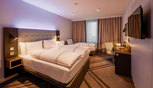 a hotel room with a large bed and a desk at Premier Inn Stuttgart City Europaviertel in Stuttgart