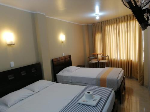una camera d'albergo con due letti e un tavolo di HOSTAL LA NOCHE - Pisco a Pisco