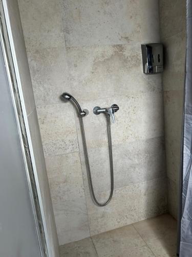 a shower with a hose in a bathroom at Hostel Balkan express in Zagreb