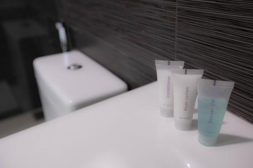 a row of four cups on a counter in a bathroom at EKHO Weligama in Weligama