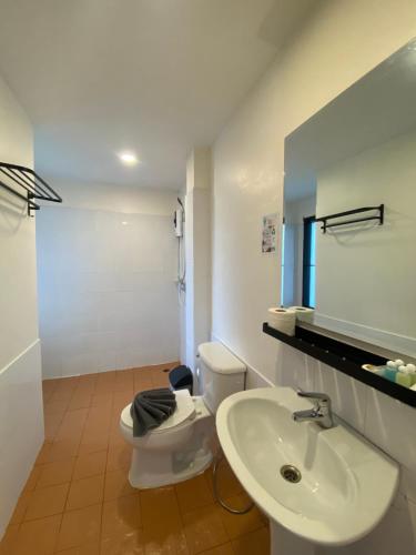 a white bathroom with a toilet and a sink at Phangan Utopia Resort in Mae Haad