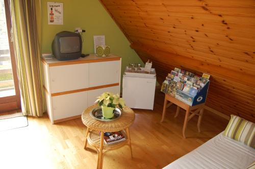 sala de estar con TV y mesa en B&B Des Bois Sans Nombre, en Paliseul