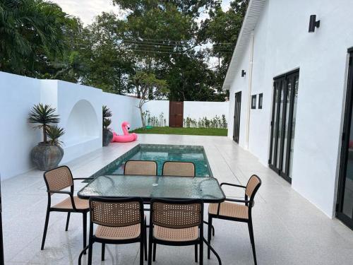 a patio with a table and chairs and a pool at Arau House in Arau