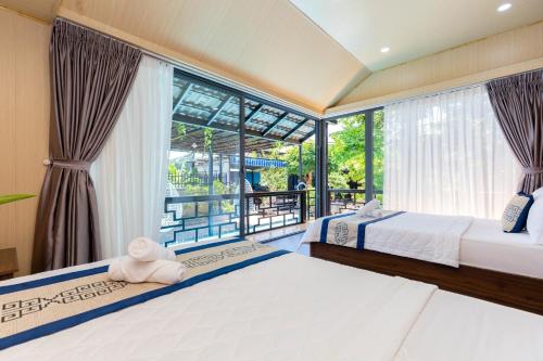 头顿Villages 5 Nguyễn Đình Tứ的一间有两张床和一扇大窗户的卧室