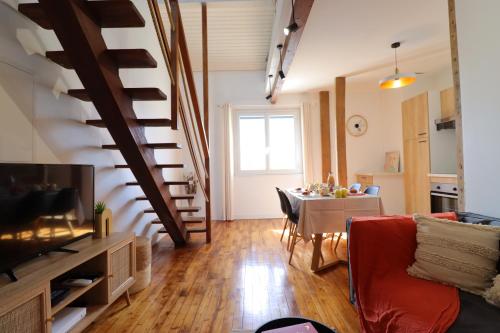 sala de estar con mesa y escalera de caracol en Le Boho - Charmant T3 - gare à 5 min à pieds, en Bergerac