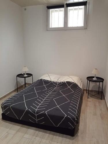 Ce lit se trouve dans une chambre blanche avec 2 tables de chevet. dans l'établissement Jolie maison de ville avec jardin arboré, à La Seyne-sur-Mer