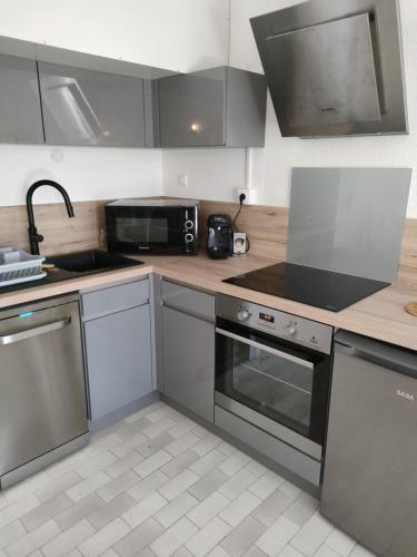 une cuisine avec un évier et une cuisinière four supérieur dans l'établissement Au petit bonheur 2, à Sanary-sur-Mer