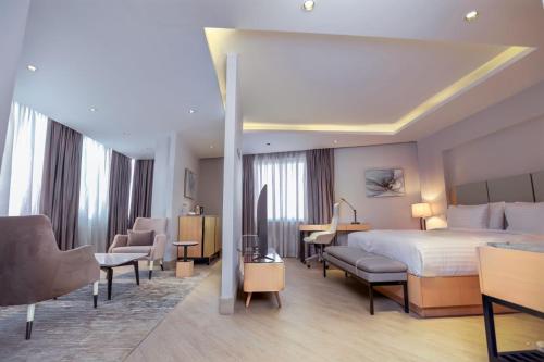 アディスアベバにあるThe Row Residential Hotelのベッドと机があるホテルの部屋