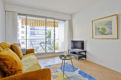 un salon avec un canapé et une télévision dans l'établissement Appartement Herta - Welkeys, à Biarritz