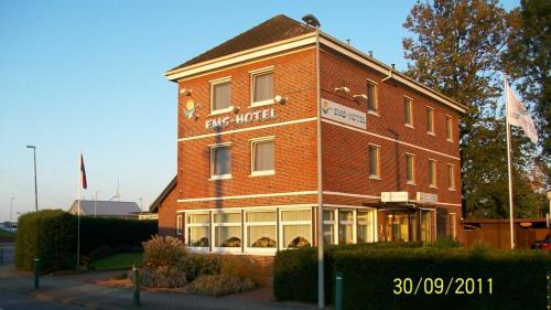 a brick building with a sign on the side of it at Ems-Hotel in Emden
