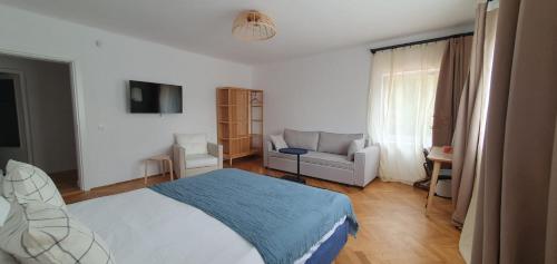 - une chambre avec un lit et un canapé dans l'établissement The Pines Serviced Apartments, à Braşov